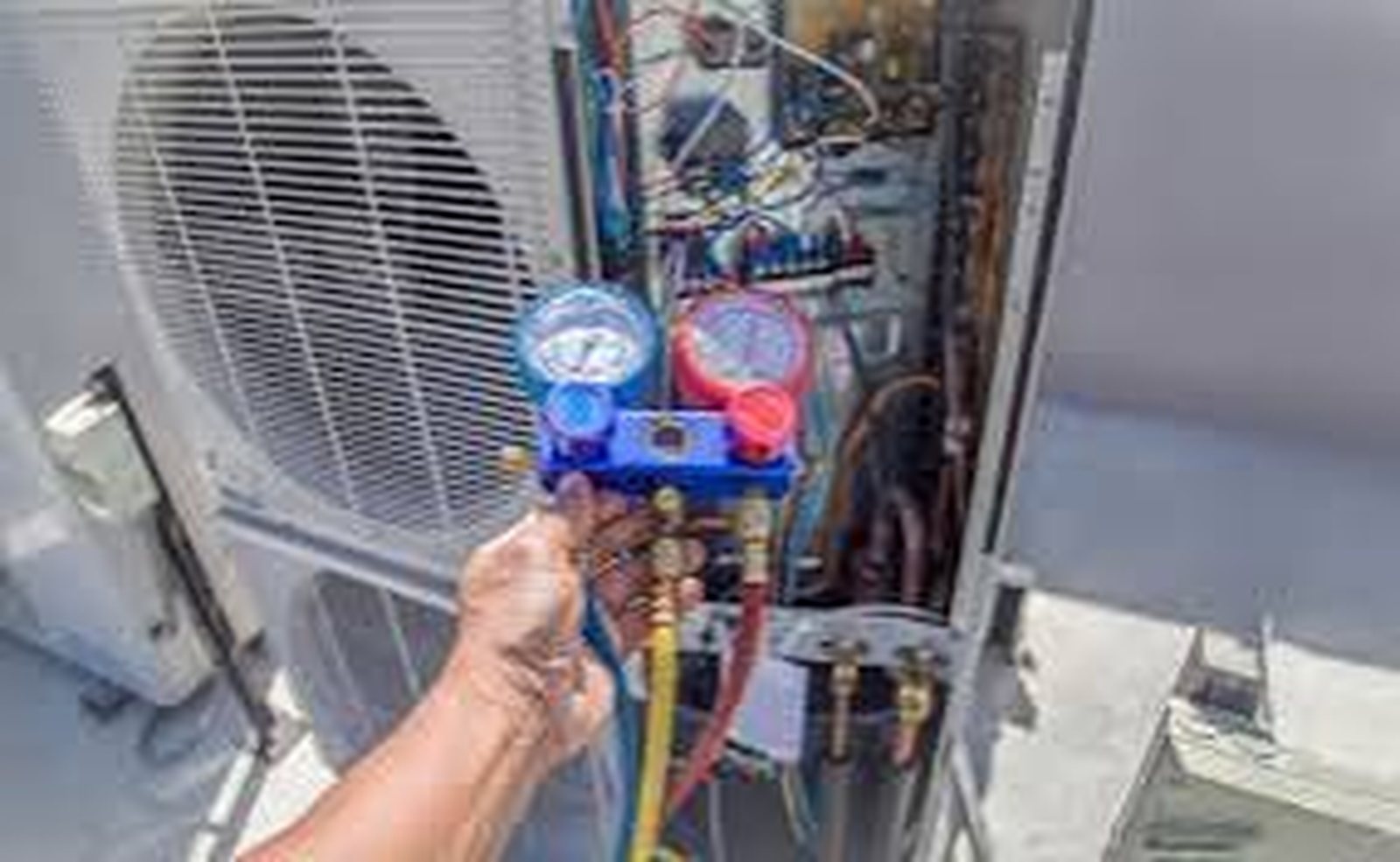 Mini split refrigerant recharge gauges connected to outdoor unit service ports